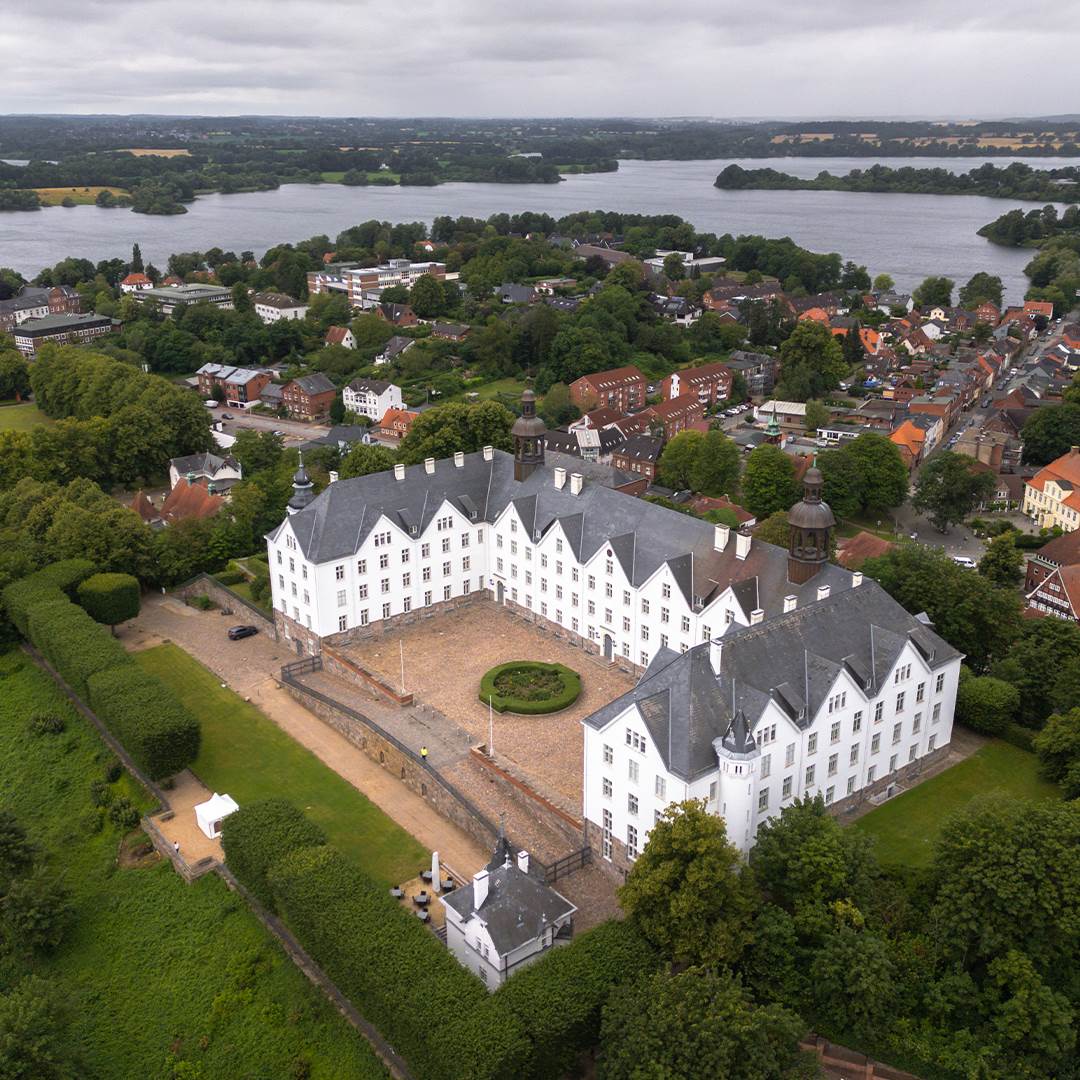 Plöner Schloss med den omkringliggende by og søer.